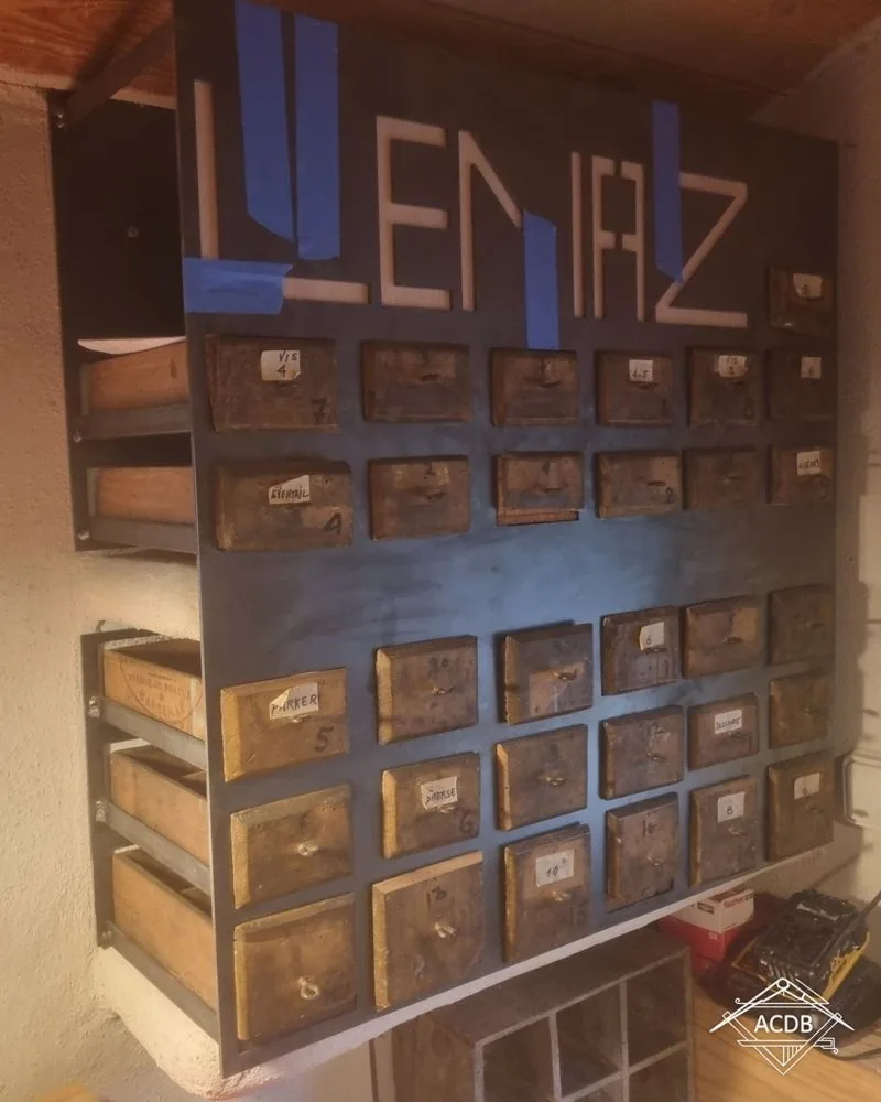 Mur de casiers où chaque ancienne caisse en bois sert de tiroir